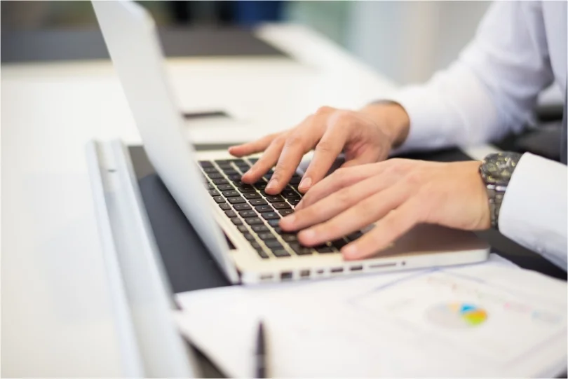 Mains qui tappent écrivent sur clavier de laptop ordinateur portable documents en ligne numérisation