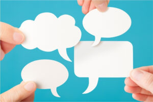 Bulles de dialogue tenues par des mains devant un fond bleu